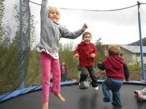 Kateri and Isaiah jumping with their neighbour friend, Carter